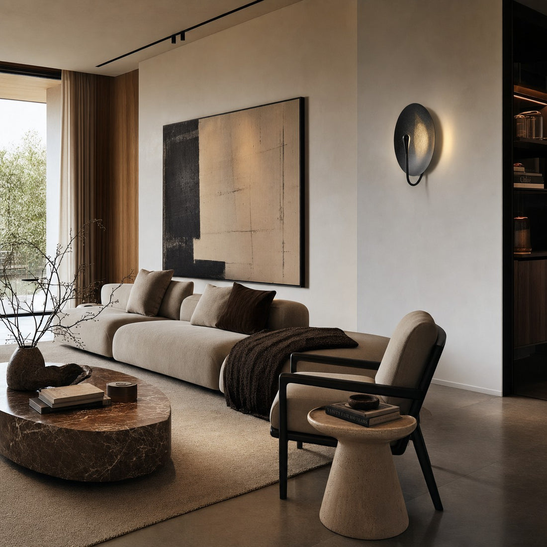 Black sculptural disc wall sconce in a modern living room