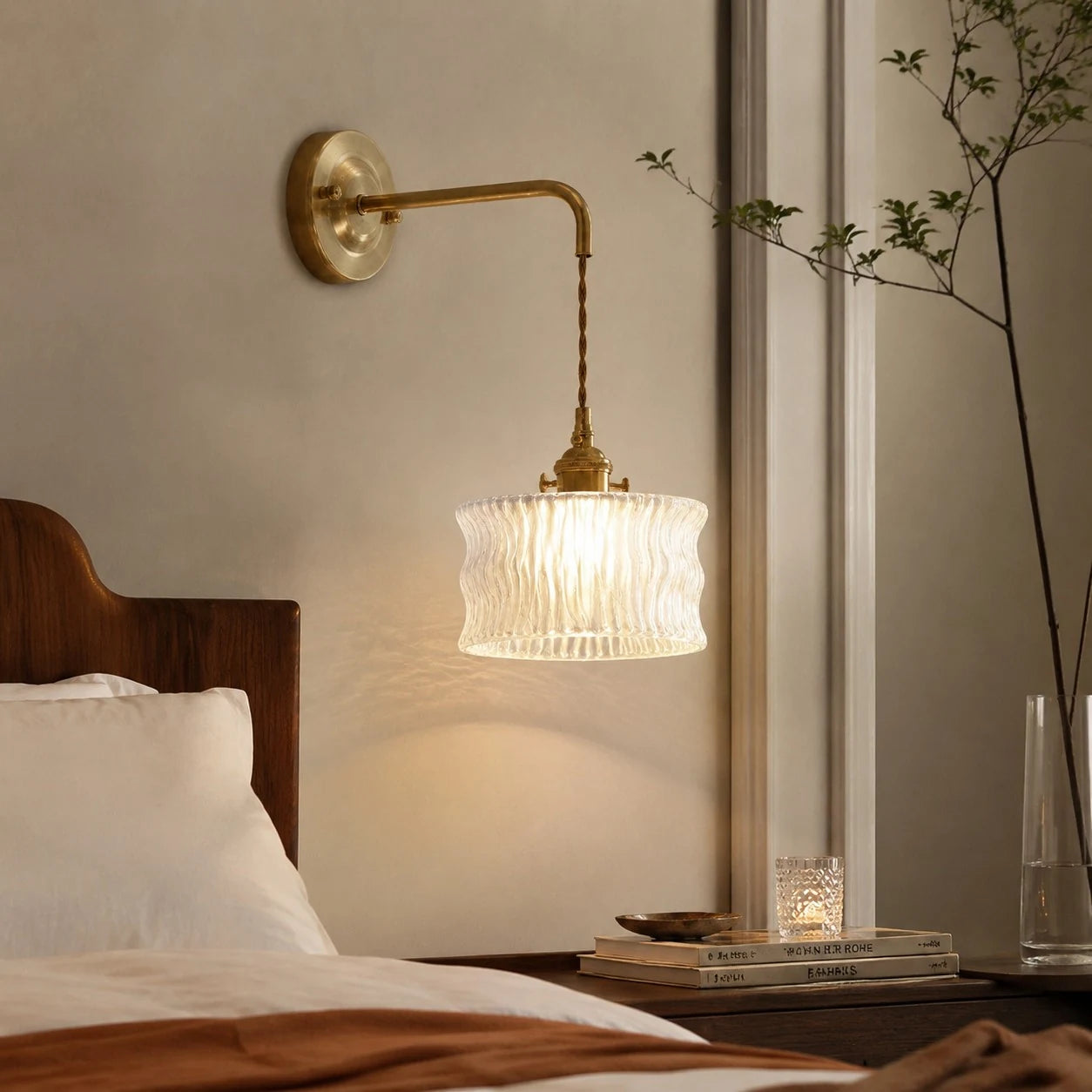 White ripple glass wall sconce mounted above a bedside table