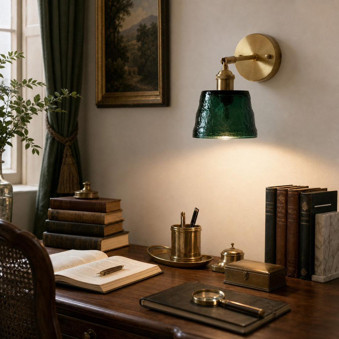 Green brass glass wall sconce above a writing desk