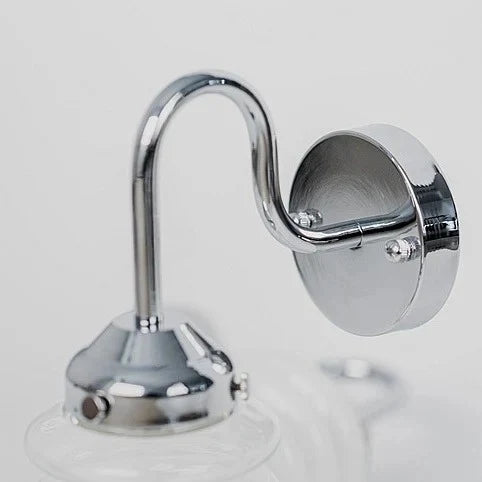 Curved chrome arm and round wall plate detail