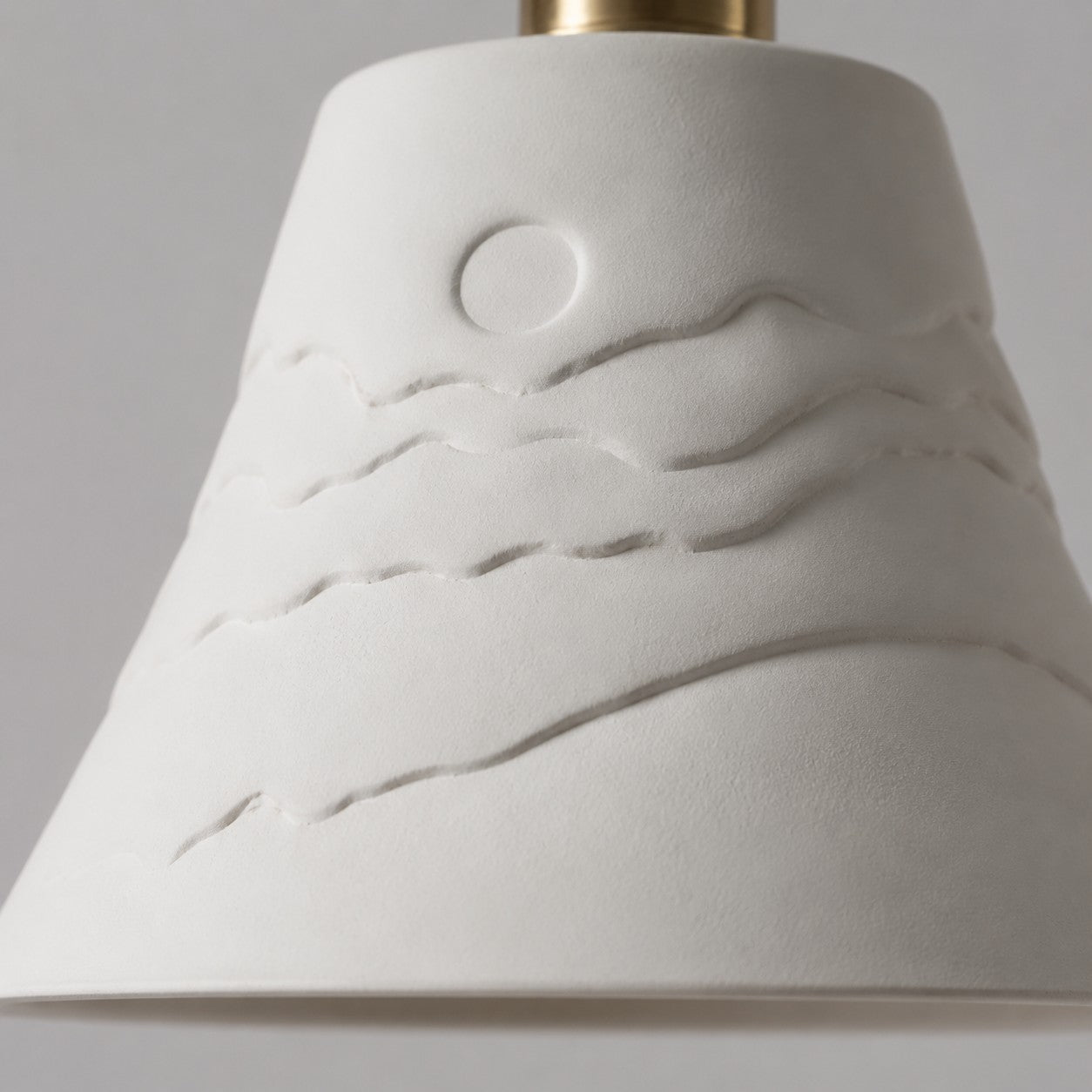 Raised sunset relief detail on the ceramic shade