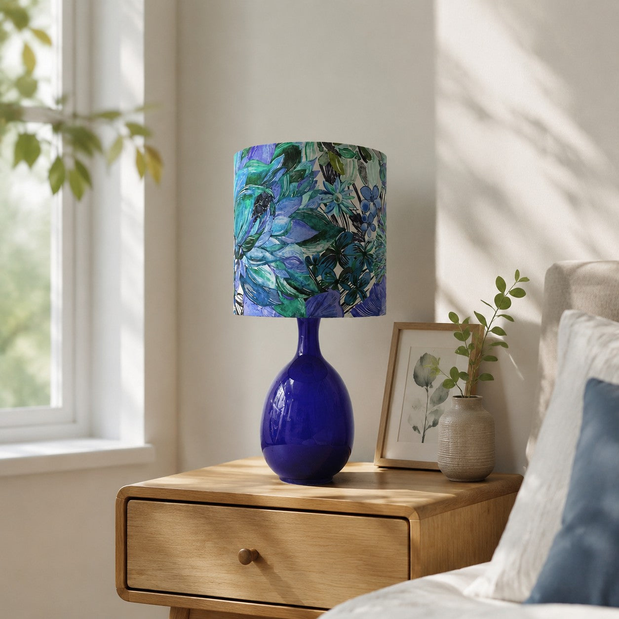 Green botanical fabric ceramic table lamp in a bedroom setting