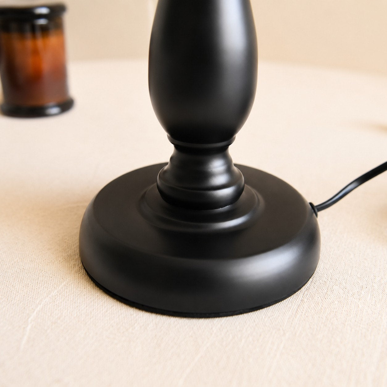 Close view of black iron lamp base and cord