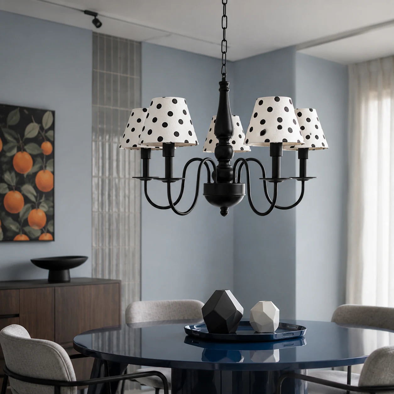 Black polka dot chandelier above a modern dining table