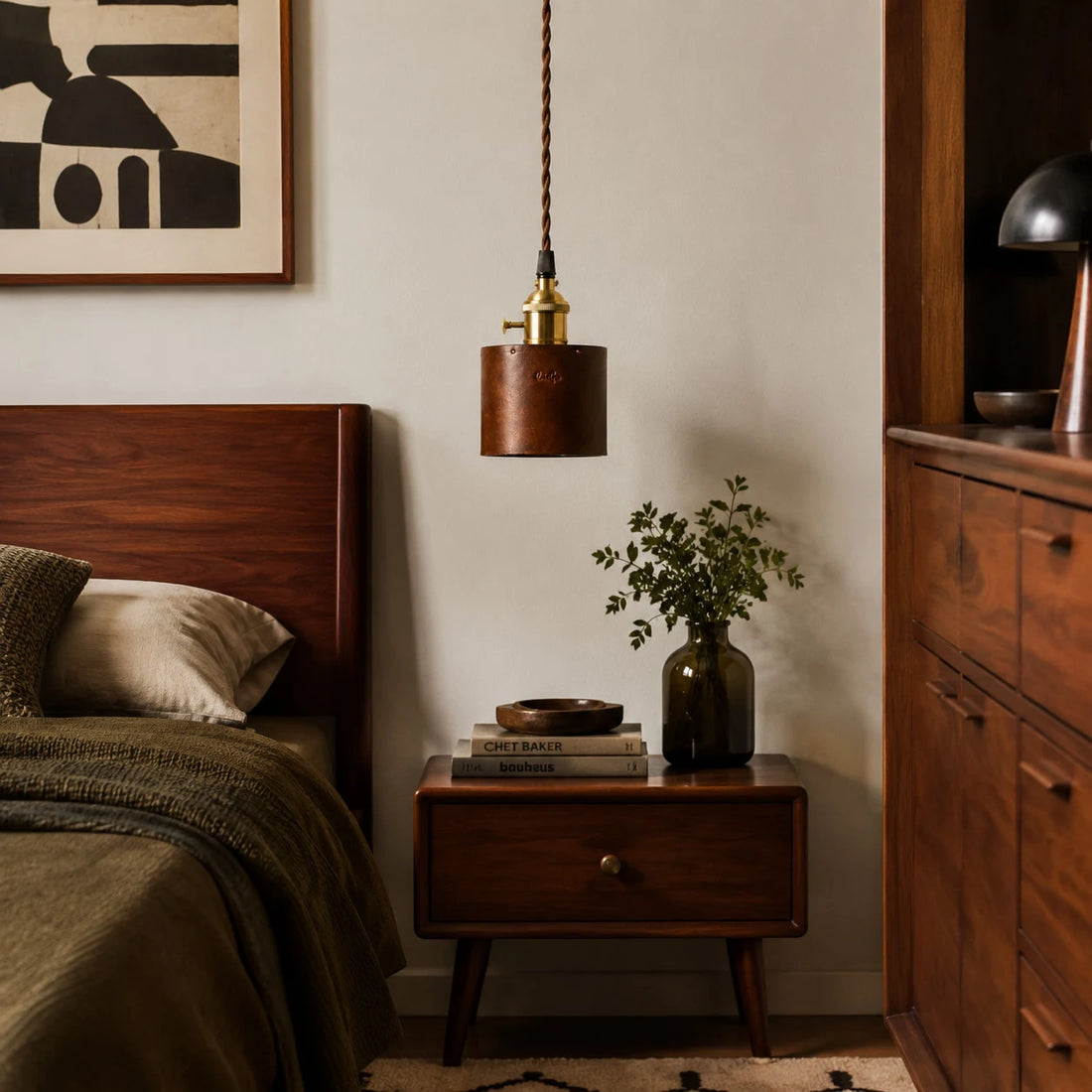 Brown leather pendant lamp above a bedside table
